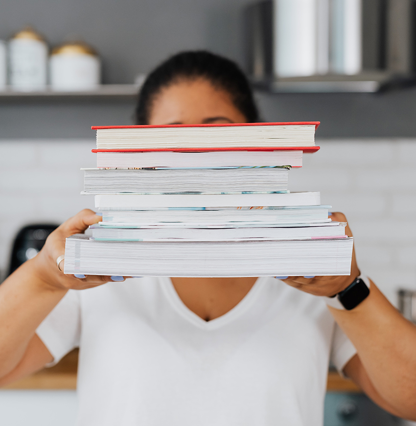 personne tenant une pile de livres